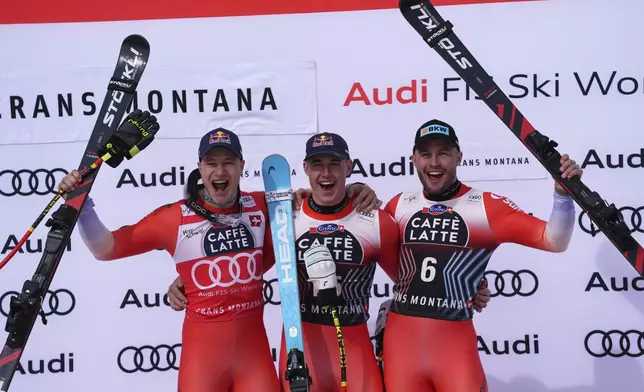 From left, second placed Switzerland's Marco Odermatt, the winner Switzerland's Franjo von Allmen and third placed Switzerland's Alexis Monney celebrate after an alpine ski, men's World Cup downhill, in Crans Montana, Switzerland, Saturday, Feb. 22, 2025. (AP Photo/Giovanni Auletta)