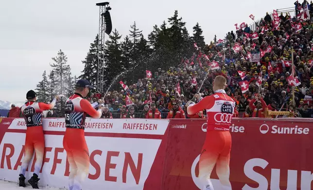 Second placed Switzerland's Marco Odermatt, the winner Switzerland's Franjo von Allmen and third placed Switzerland's Alexis Monney celebrate after an alpine ski, men's World Cup downhill, in Crans Montana, Switzerland, Saturday, Feb. 22, 2025. (AP Photo/Giovanni Auletta)