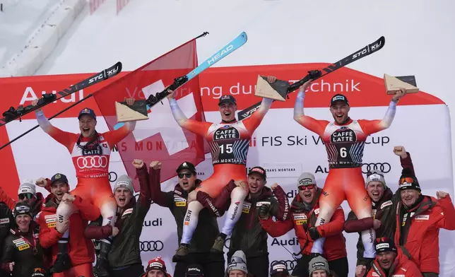 From left, second placed Switzerland's Marco Odermatt, the winner Switzerland's Franjo von Allmen and third placed Switzerland's Alexis Monney celebrate after an alpine ski, men's World Cup downhill, in Crans Montana, Switzerland, Saturday, Feb. 22, 2025. (AP Photo/Giovanni Auletta)