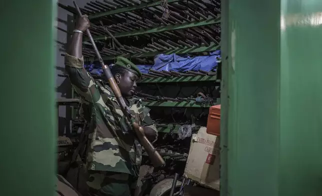 Ndeye Seck, a sublieutenant with Senegal's Direction of National Parks, sifts through confiscated guns at the DPN headquarters in Tambacounda, Senegal on Monday, Jan. 13, 2025. (AP Photo/Annika Hammerschlag)