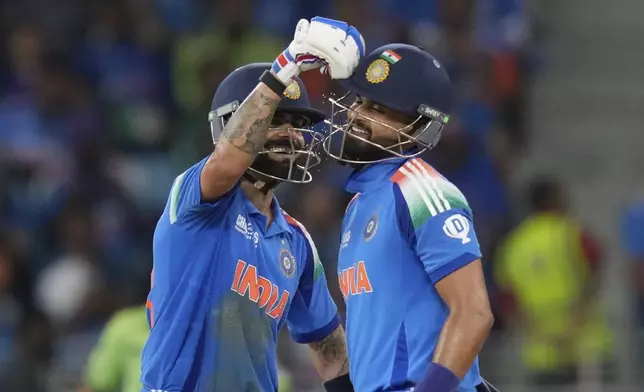 India's Virat Kohli, left, congratulates his fellow batsman Shreyas Iyer after he scored fifty runs during the ICC Champions Trophy cricket match between India and Pakistan at Dubai International Cricket Stadium, United Arab Emirates, Sunday, Feb. 23, 2025. (AP Photo/Altaf Qadri)