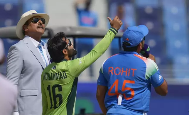 Pakistan's captain Mohammad Rizwan, centre, tosses the coin, as India's captain Rohit Sharma, right, looks on before the start of ICC Champions Trophy cricket match between India and Pakistan at Dubai International Cricket Stadium, United Arab Emirates, Sunday, Feb. 23, 2025. (AP Photo/Altaf Qadri)