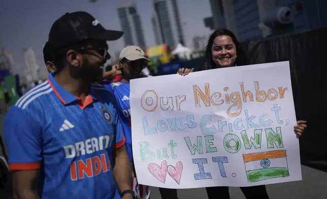 An Indian fan holds a placard as they arrive to watch the ICC Champions Trophy cricket match between India and Pakistan at Dubai International Cricket Stadium, United Arab Emirates, Sunday, Feb. 23, 2025. (AP Photo/Altaf Qadri)