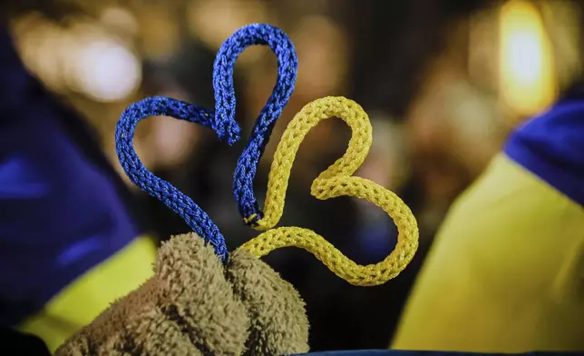 A hand of demonstrator holding hearts in Ukrainian flag colors as Bulgarians and Ukrainian refugees express their solidarity with with Ukrainians who have fought for their freedom for three years since the start of the Russian invasion, Sofia, Monday, Feb. 24, 2025. (AP Photo/Valentina Petrova)