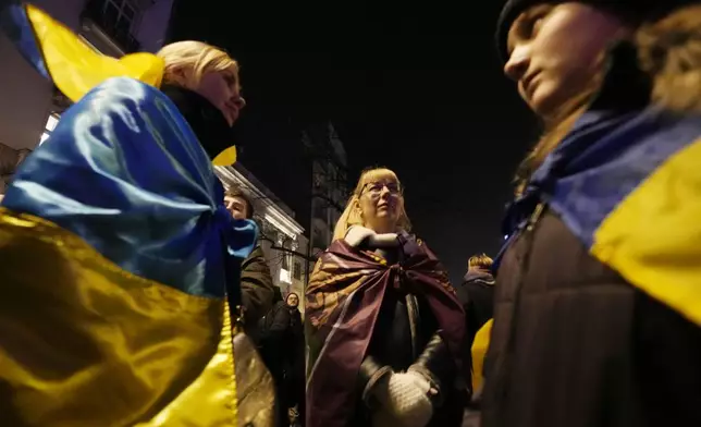 Ukrainian and Polish anti-war activists of the Euromaidan-Warsaw group mark the third anniversary of Russia's invasion of Ukraine, in front of the Ukrainian Embassy in Warsaw, Poland, Monday, Feb. 24, 2025. (AP Photo/Czarek Sokolowski)