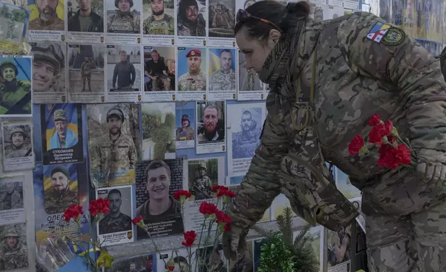 A serviceman mourns at the Memorial Wall of Fallen Defenders of Ukraine in Russian-Ukrainian War in Kyiv, Ukraine, Monday, Feb. 24, 2025. (AP Photo/Andrew Kravchenko)