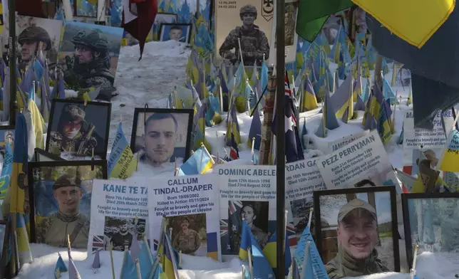 Flags with portraits of soldiers are seen at a makeshift memorial for fallen soldiers in Russian-Ukrainian war, on Independence Square in Kyiv, Ukraine, Monday, Feb. 24, 2025. (AP Photo/Efrem Lukatsky)