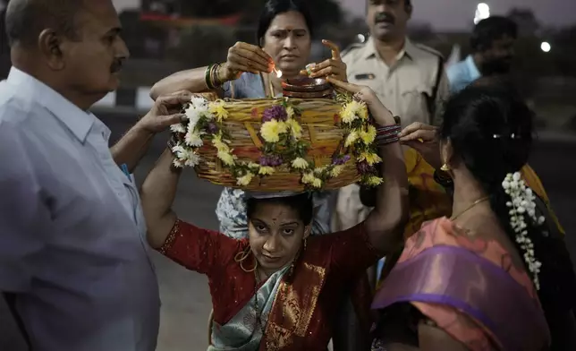A devotee carries a basket full of ceremonial offerings at the Lingamanthula Swamy temple during a Hindu pilgrimage called the Peddagattu Jatara, in Suryapet, Telangana state, India, Sunday, Feb. 16, 2025. (AP Photo /Mahesh Kumar A.)
