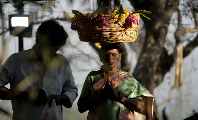 A devotee carries ceremonial offerings in a basket on her head at the Lingamanthula Swamy temple during a Hindu pilgrimage called the Peddagattu Jatara, in Suryapet, Telangana state, India, Sunday, Feb. 16, 2025. (AP Photo /Mahesh Kumar A.)