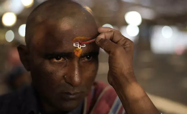 A devotee gets his forehead marked with a holy symbol at the Lingamanthula Swamy temple during a Hindu pilgrimage called the Peddagattu Jatara, in Suryapet, Telangana state, India, Sunday, Feb. 16, 2025. (AP Photo /Mahesh Kumar A.)