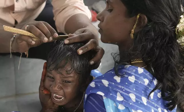 A young boy gets his head shaved at the Lingamanthula Swamy temple during a Hindu pilgrimage called the Peddagattu Jatara, in Suryapet, Telangana state, India, Tuesday, Feb. 18, 2025. (AP Photo /Mahesh Kumar A.)