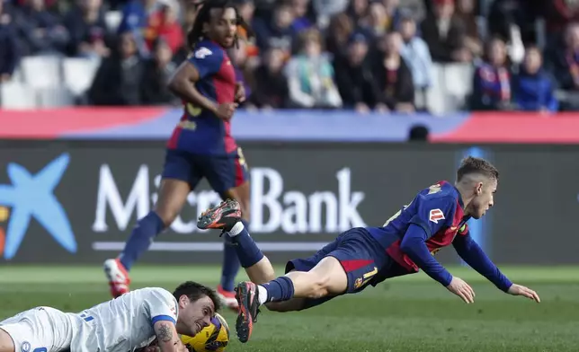 Alaves' Ander Guevara, left and Barcelona's Fermin Lopez fall during a Spanish La Liga soccer match between Barcelona and Alaves at the Lluis Companys Olympic Stadium in Barcelona, Spain, Sunday Feb. 2, 2025. (AP Photo/Joan Monfort)