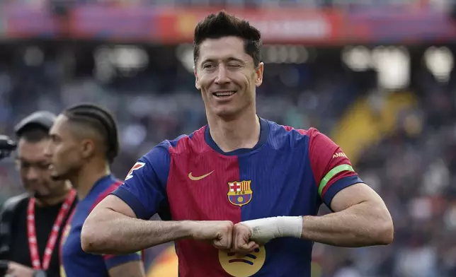 Barcelona's Robert Lewandowski winks as he celebrates after scoring the opening goal during a Spanish La Liga soccer match between Barcelona and Alaves at the Lluis Companys Olympic Stadium in Barcelona, Spain, Sunday Feb. 2, 2025. (AP Photo/Joan Monfort)