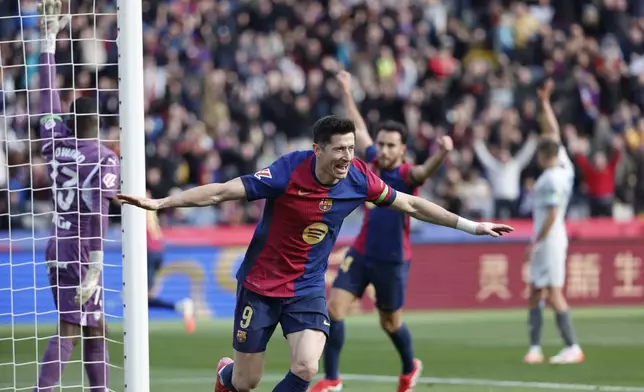 Barcelona's Robert Lewandowski celebrates after scoring the opening goal during a Spanish La Liga soccer match between Barcelona and Alaves at the Lluis Companys Olympic Stadium in Barcelona, Spain, Sunday Feb. 2, 2025. (AP Photo/Joan Monfort)