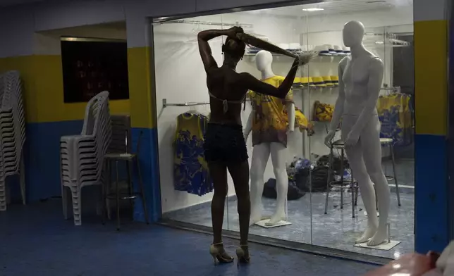 A transgender woman waits for the start of a samba reharsal class at the Paraiso de Tuiuti samba school for the Carnival parade in Rio de Janeiro, Wednesday, Feb. 5, 2025. (AP Photo/Silvia Izquierdo)