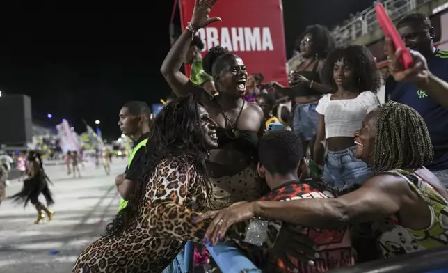 Transgender woman Andreia, left, greets fans during a Paraiso de Tuiuti samba school rehearsal for the Carnival parade at the Sambadrome in Rio de Janeiro, Saturday, Feb. 22, 2025. (AP Photo/Silvia Izquierdo)
