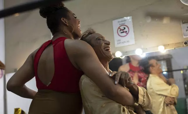 Transgender women Alessandra Salazary, 31, left, and Ariela hug before a Carnival contest in Rio de Janeiro, Saturday, Feb. 15, 2025. (AP Photo/Silvia Izquierdo)