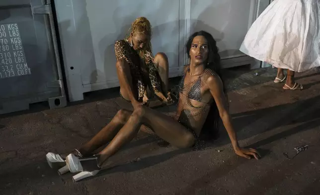 Transgender women with the Paraiso de Tuiuti samba school rest after rehearing for the Carnival parade at the Sambodrome in Rio de Janeiro, Saturday, Feb. 22, 2025. (AP Photo/Silvia Izquierdo)
