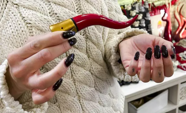 Delia D'Alessandro explains the origins and use of the Neapolitan horn in the family's shop in Naples, southern Italy, Wednesday, Feb. 12, 2025. (AP Photo/Trisha Thomas)
