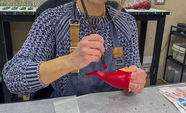 Marianna Mattei puts a final touch on Neapolitan horns in a shop in Naples, southern Italy, Wednesday, Feb. 12, 2025. (AP Photo/Giada Zampano)