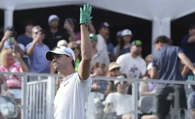 Thomas Detry, of Belgium, waves to the cheering crowd after hitting his tee shot close to the pin on the 16th hole during the final round of the Phoenix Open golf tournament at TPC Scottsdale, Sunday, Feb. 9, 2025, in Scottsdale, Ariz. (AP Photo/Ross D. Franklin)