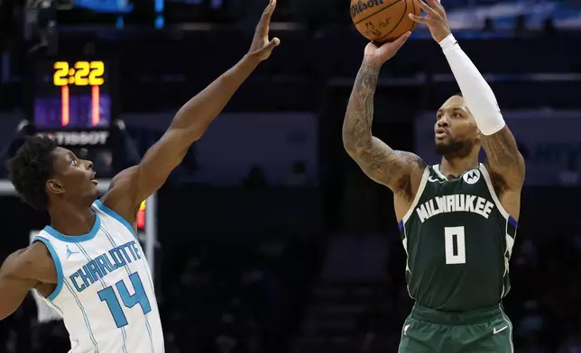 Milwaukee Bucks guard Damian Lillard (0) shoots over Charlotte Hornets forward Moussa Diabate during the second half of an NBA basketball game in Charlotte, N.C., Wednesday, Feb. 5, 2025. (AP Photo/Nell Redmond)