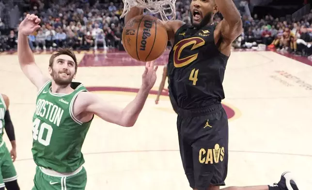 Cleveland Cavaliers forward Evan Mobley (4) dunks in front of Boston Celtics center Luke Kornet (40) in the second half of an NBA basketball game, Tuesday, Feb. 4, 2025, in Cleveland. (AP Photo/Sue Ogrocki)