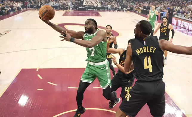 Boston Celtics guard Jaylen Brown (7) shoots in front of Cleveland Cavaliers forward Evan Mobley (4) in the first half of an NBA basketball game, Tuesday, Feb. 4, 2025, in Cleveland. (AP Photo/Sue Ogrocki)