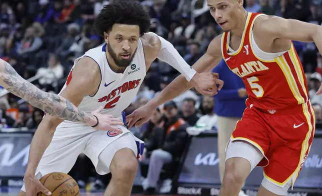 Detroit Pistons guard Cade Cunningham, left, drives to the basket against Atlanta Hawks guard Dyson Daniels (5) during the second half of an NBA basketball game Monday, Feb. 3, 2025, in Detroit. (AP Photo/Duane Burleson)