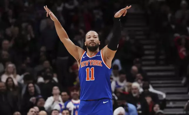 New York Knicks' Jalen Brunson (11) celebrates a 3-point basket against the Toronto Raptors during the second half of an NBA basketball game in Toronto on Tuesday, Feb. 4, 2025. (Nathan Denette/The Canadian Press via AP)