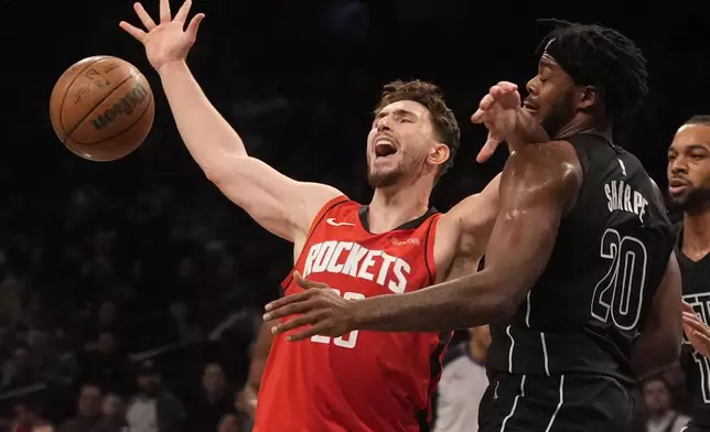 Houston Rockets' Alperen Sengun, left, fights for control of the ball with Brooklyn Nets' Day'Ron Sharpe, right, during the second half of an NBA basketball game Tuesday, Feb. 4, 2025, in New York. (AP Photo/Frank Franklin II)