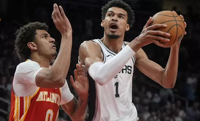 San Antonio Spurs center Victor Wembanyama (1) shoots against Atlanta Hawks Dominick Barlow during the first half of an NBA basketball game, Wednesday, Feb. 5, 2025, in Atlanta. (AP Photo/Mike Stewart)