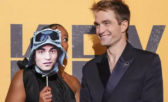Naomi Ackie, left, and Robert Pattinson pose for photographers upon arrival at the World premiere for the film 'Mickey 17' on Thursday, Feb. 13, 2025, in London. (Photo by Scott A Garfitt/Invision/AP)