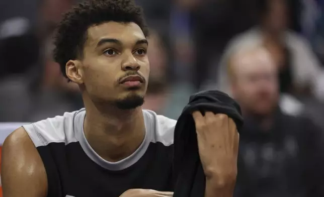 FILE - San Antonio Spurs center Victor Wembanyama sits on the bench during an NBA basketball game against the Sacramento Kings in Sacramento, Calif, Sunday, Dec. 1, 2024. (AP Photo/Jed Jacobsohn, File)