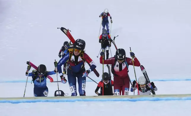 Athletes compete during the women's mixed relay race at the Ski Mountaineering World Cup event in Bormio, Italy, Sunday, Feb. 23, 2025. (AP Photo/Antonio Calanni)