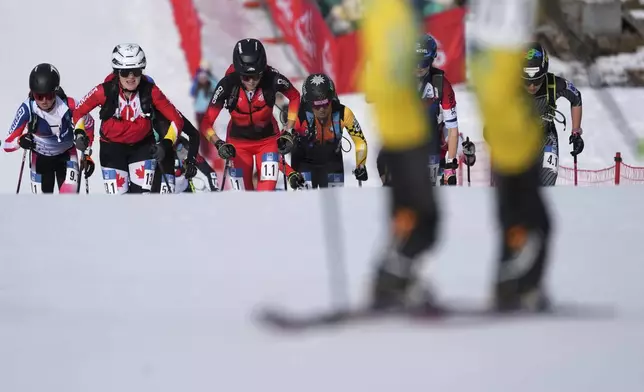 Athletes compete during the women's mixed relay race at the Ski Mountaineering World Cup event in Bormio, Italy, Sunday, Feb. 23, 2025. (AP Photo/Antonio Calanni)