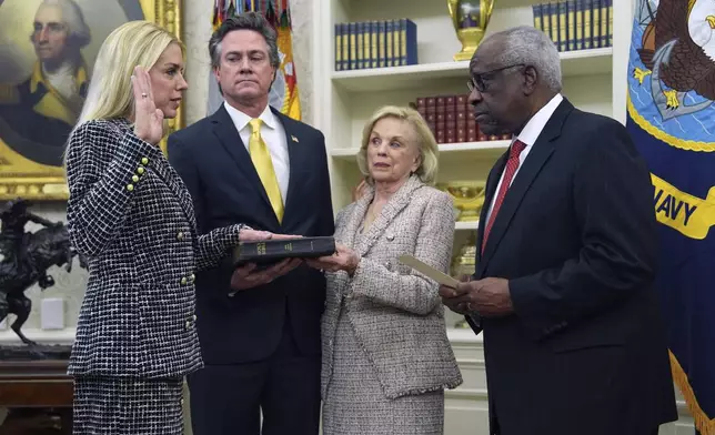 Pam Bondi is sworn in as Attorney General by Supreme Court Associate Justice Clarence Thomas, right, as partner John Wakefield and mother Patsy Bondi, look on, in the Oval Office of the White House, Wednesday, Feb. 5, 2025, in Washington. (AP Photo/Evan Vucci)