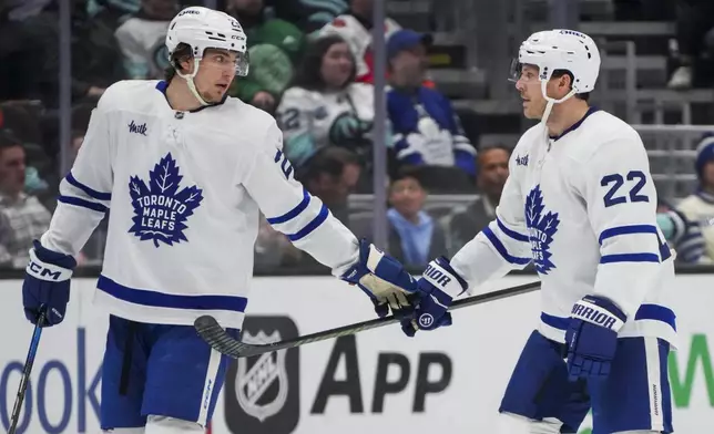 Toronto Maple Leafs left wing Matthew Knies, left, celebrates his goal with defenseman Jake McCabe, right, during the second period of an NHL hockey game against the Seattle Kraken Thursday, Feb. 6, 2025, in Seattle. (AP Photo/Lindsey Wasson)