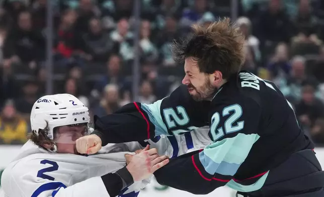 Toronto Maple Leafs defenseman Simon Benoit, left, gets punched by Seattle Kraken right wing Oliver Bjorkstrand, right, as they fight during the second period of an NHL hockey game Thursday, Feb. 6, 2025, in Seattle. (AP Photo/Lindsey Wasson)