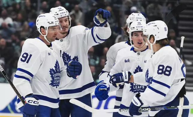 Toronto Maple Leafs defenseman Philippe Myers, second from left, celebrates his goal against the Seattle Kraken with center John Tavares (91), right wing Mitch Marner (16) and right wing William Nylander (88) during the first period of an NHL hockey game Thursday, Feb. 6, 2025, in Seattle. (AP Photo/Lindsey Wasson)