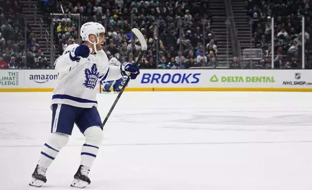 Toronto Maple Leafs center Max Domi celebrates after assisting center Bobby McMann on a goal against the Seattle Kraken during the first period of an NHL hockey game Thursday, Feb. 6, 2025, in Seattle. (AP Photo/Lindsey Wasson)