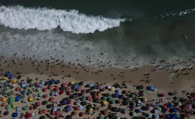 People flock to Ipanema beach during summer in Rio de Janeiro, Sunday, Feb. 16, 2025. (AP Photo/Bruna Prado)