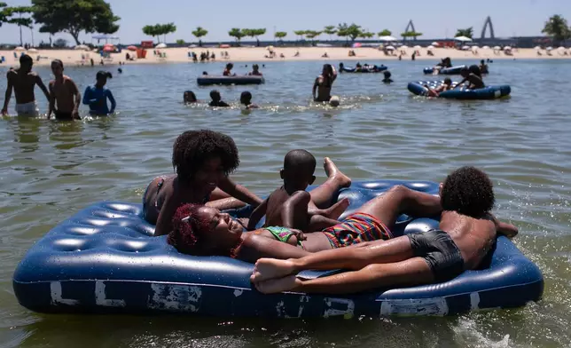 People lie on an inflatable mattress at the Piscinao de Ramos artificial beach during summer in Rio de Janeiro, Sunday, Feb. 16, 2025. (AP Photo/Bruna Prado)