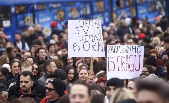 People hold banners read: "One world one fight" and "We demand an investigation" during a protest following flash floods and landslides that killed 19 people more than four months ago, in Sarajevo, Bosnia, Monday, Feb. 10, 2025. (AP Photo/Armin Durgut)