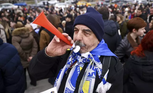 A man blows a horn during a protest following flash floods and landslides that killed 19 people more than four months ago, in Sarajevo, Bosnia, Monday, Feb. 10, 2025. (AP Photo/Armin Durgut)