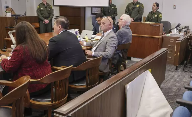 Jeffrey Ferguson, an Orange County Superior Court judge, sitting far right, who allegedly pulled a gun from his ankle holster and fatally shot his wife, stands on trial during opening statements with his attorney Cameron Talley, sitting second from right, at the Santa Ana Courthouse in Santa Ana, Calif., on Wednesday, Feb. 19, 2025. (Frederick M. Brown/Pool Photo via AP)