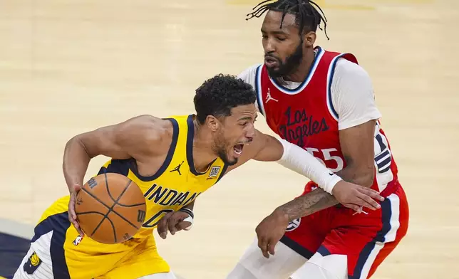 Indiana Pacers guard Tyrese Haliburton (0) drives on LA Clippers forward Derrick Jones Jr. (55) during the first half of an NBA basketball game in Indianapolis, Sunday, Feb. 23, 2025. (AP Photo/Michael Conroy)