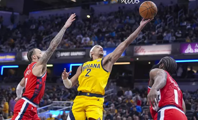Indiana Pacers guard Andrew Nembhard (2) shoots between LA Clippers guard Amir Coffey (7) and guard James Harden (1) during the first half of an NBA basketball game in Indianapolis, Sunday, Feb. 23, 2025. (AP Photo/Michael Conroy)