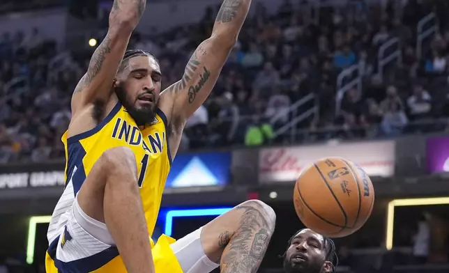 Indiana Pacers forward Obi Toppin (1) gets a basket on a dunk in front of LA Clippers forward Derrick Jones Jr. (55) during the first half of an NBA basketball game in Indianapolis, Sunday, Feb. 23, 2025. (AP Photo/Michael Conroy)