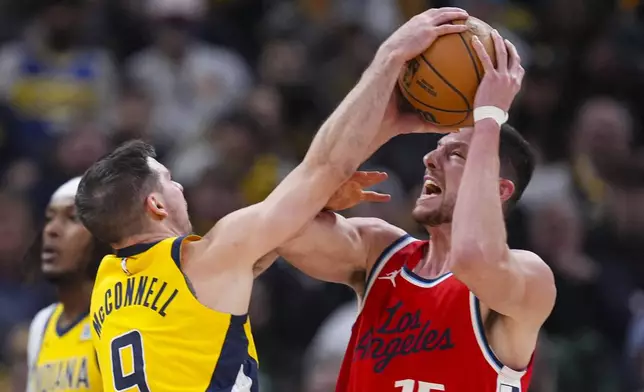 Indiana Pacers guard T.J. McConnell (9) blocks the shot of LA Clippers forward Drew Eubanks (15) during the first half of an NBA basketball game in Indianapolis, Sunday, Feb. 23, 2025. (AP Photo/Michael Conroy)